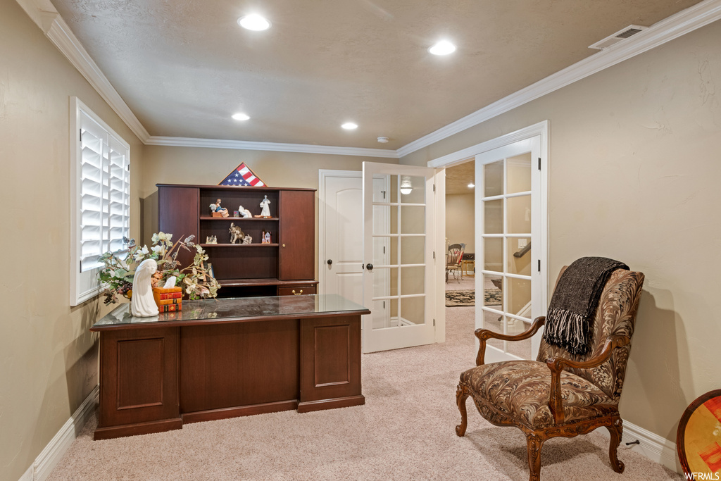 Carpeted office with ornamental molding and french doors