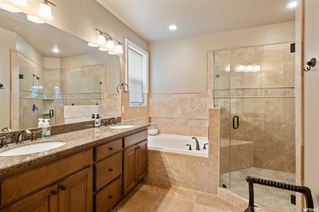 Bathroom with shower with separate bathtub, mirror, double large vanity, and light tile floors