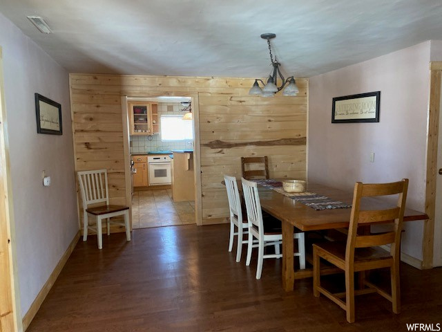 Dining room featuring wooden walls and hardwood floors