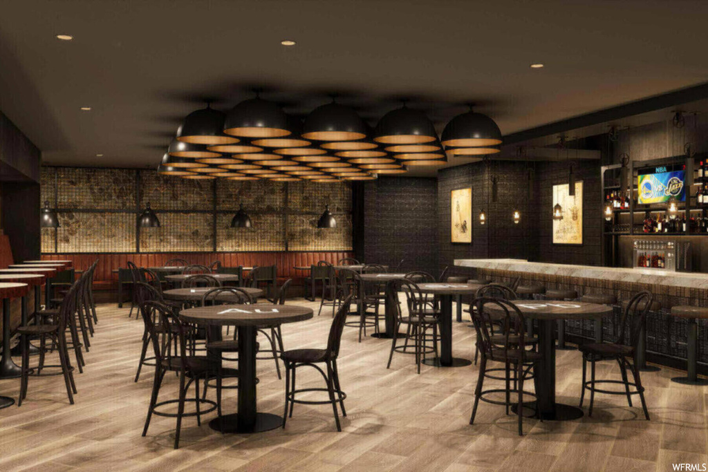 Dining area featuring bar area, light hardwood / wood-style floors, and brick wall