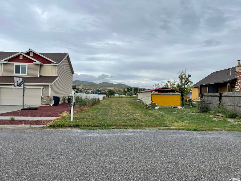 View of front facade with a front yard, a mountain view, and garage