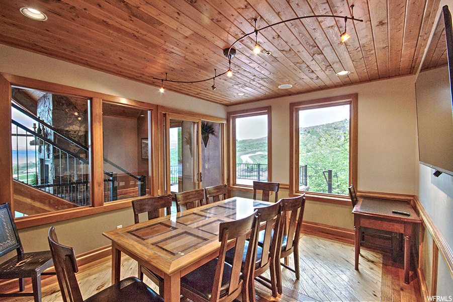 Dining space featuring wooden ceiling, light hardwood floors, and track lighting