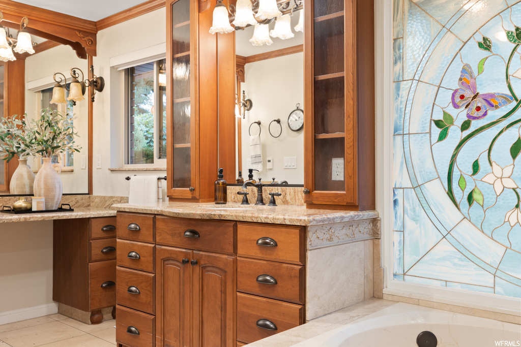 Bathroom with vanity, a bathtub, crown molding, mirror, and light tile floors