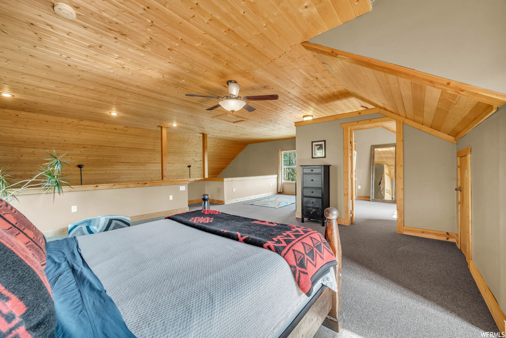 Carpeted bedroom featuring vaulted ceiling, ceiling fan, and wooden ceiling