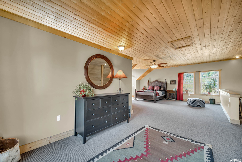 Carpeted bedroom featuring wood ceiling and ceiling fan