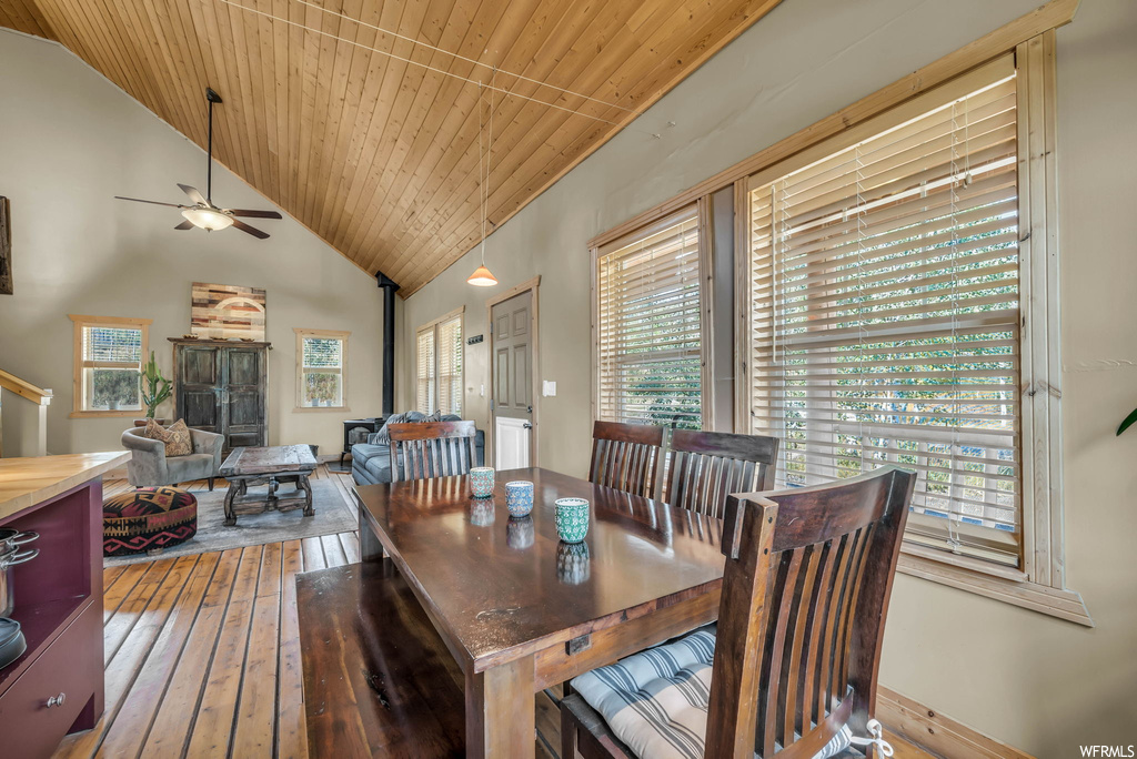 Hardwood floored dining room with vaulted ceiling, ceiling fan, and wooden ceiling