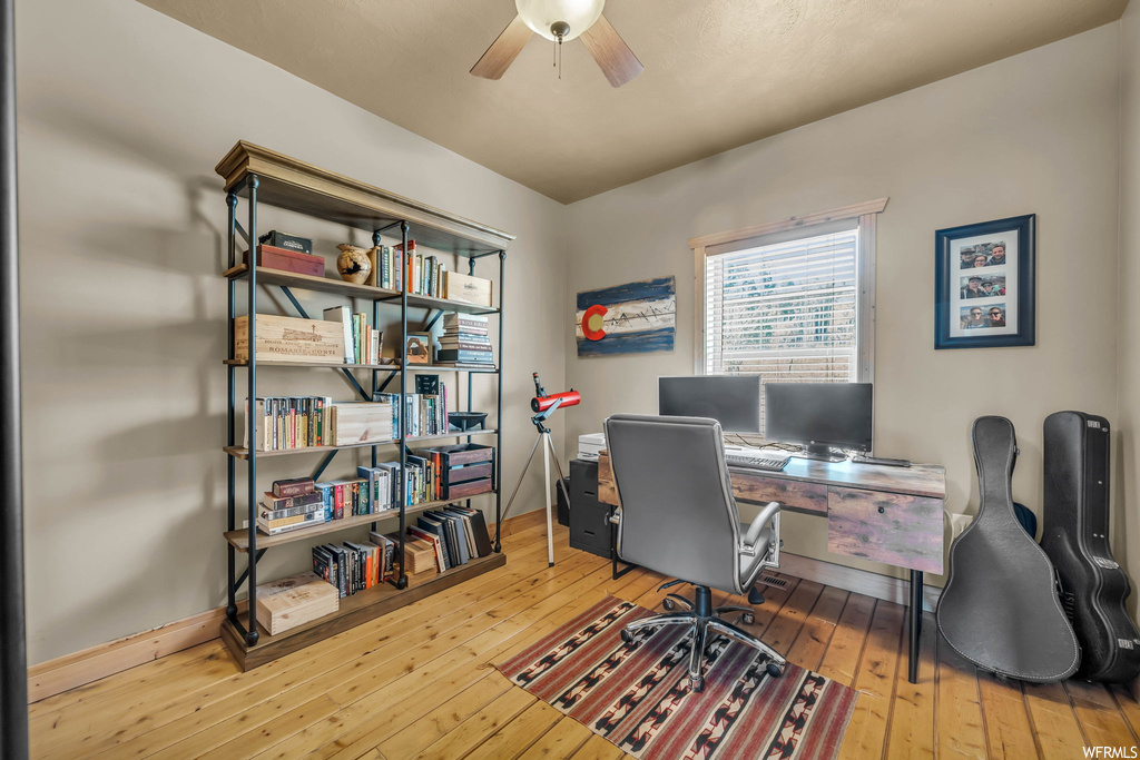 Wood floored home office with ceiling fan