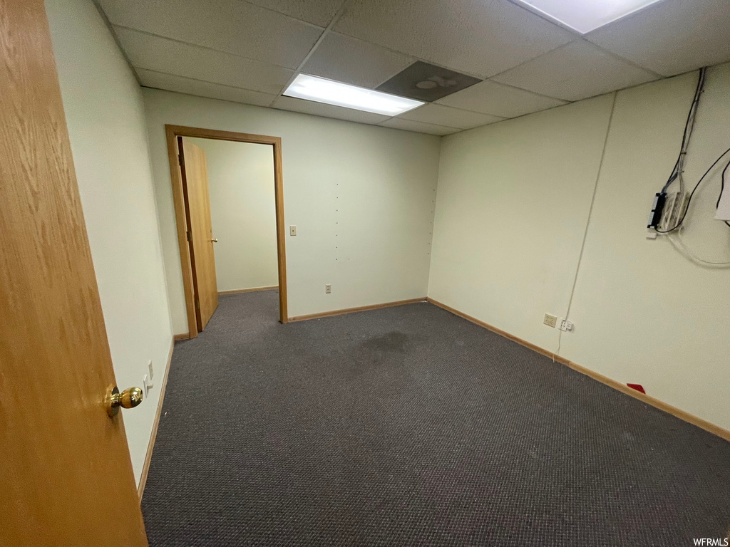 Empty room with light carpet and a drop ceiling