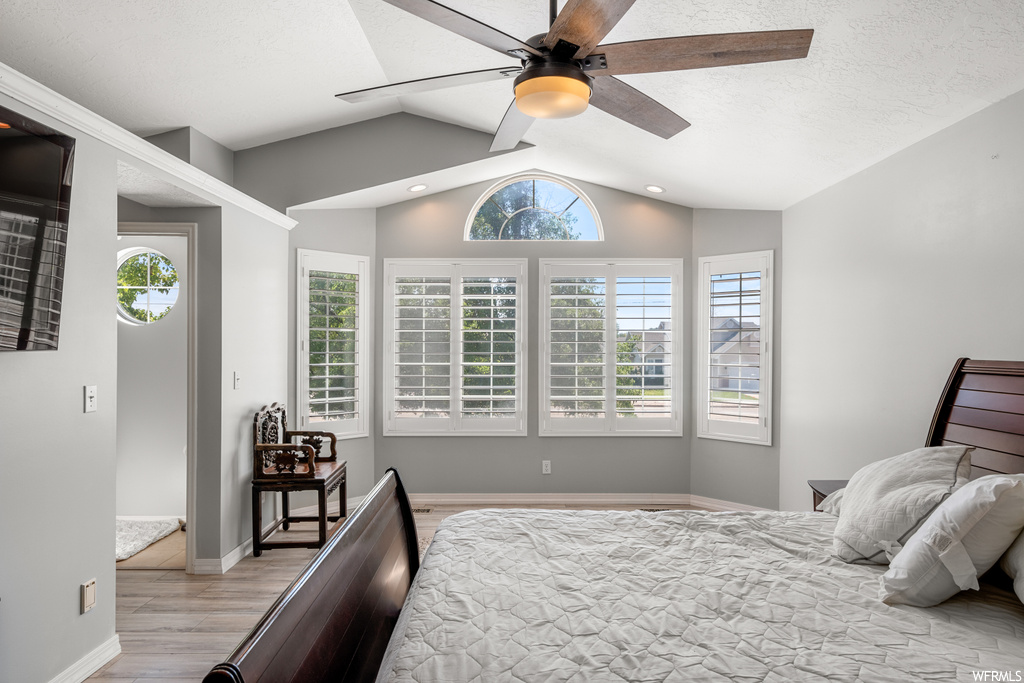 Hardwood floored bedroom with vaulted ceiling and ceiling fan