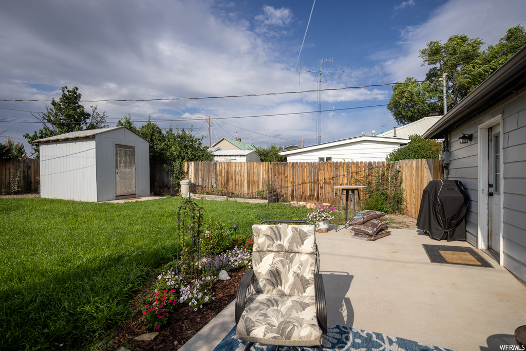 View of yard featuring a patio area and a storage shed