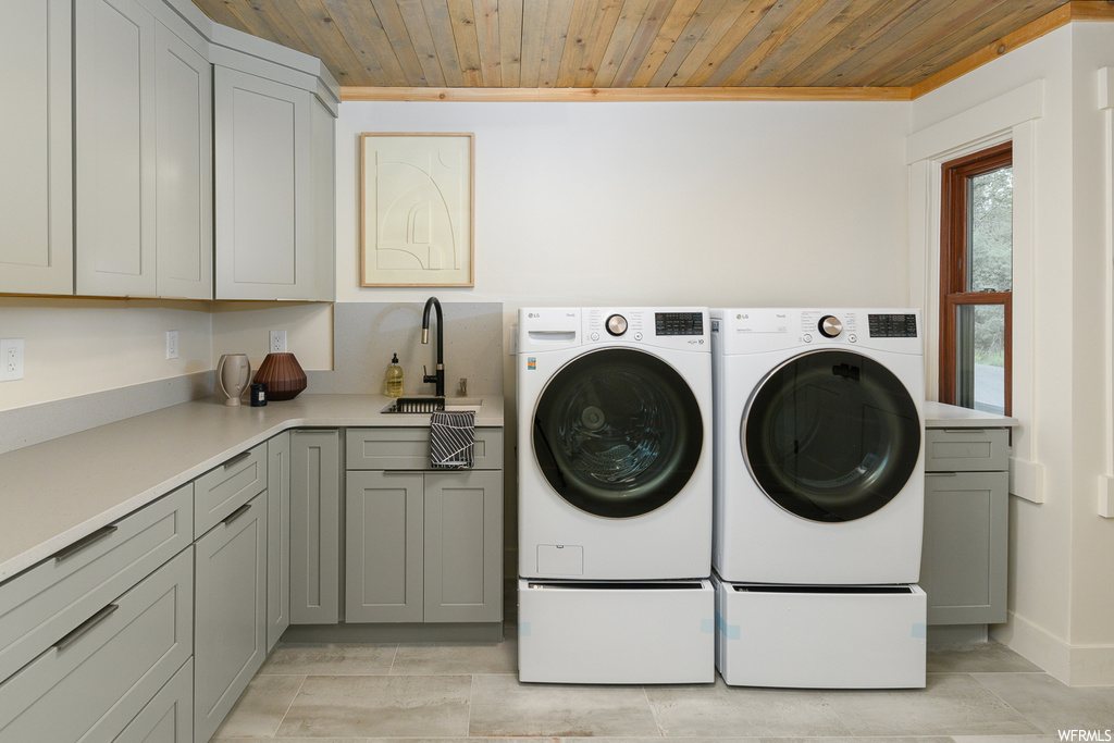 Laundry room with separate washer and dryer, ornamental molding, light tile floors, and wooden ceiling