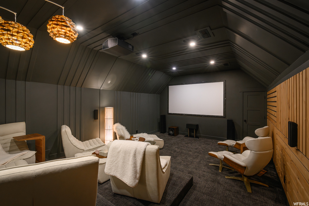 Cinema with lofted ceiling, carpet, and wooden walls