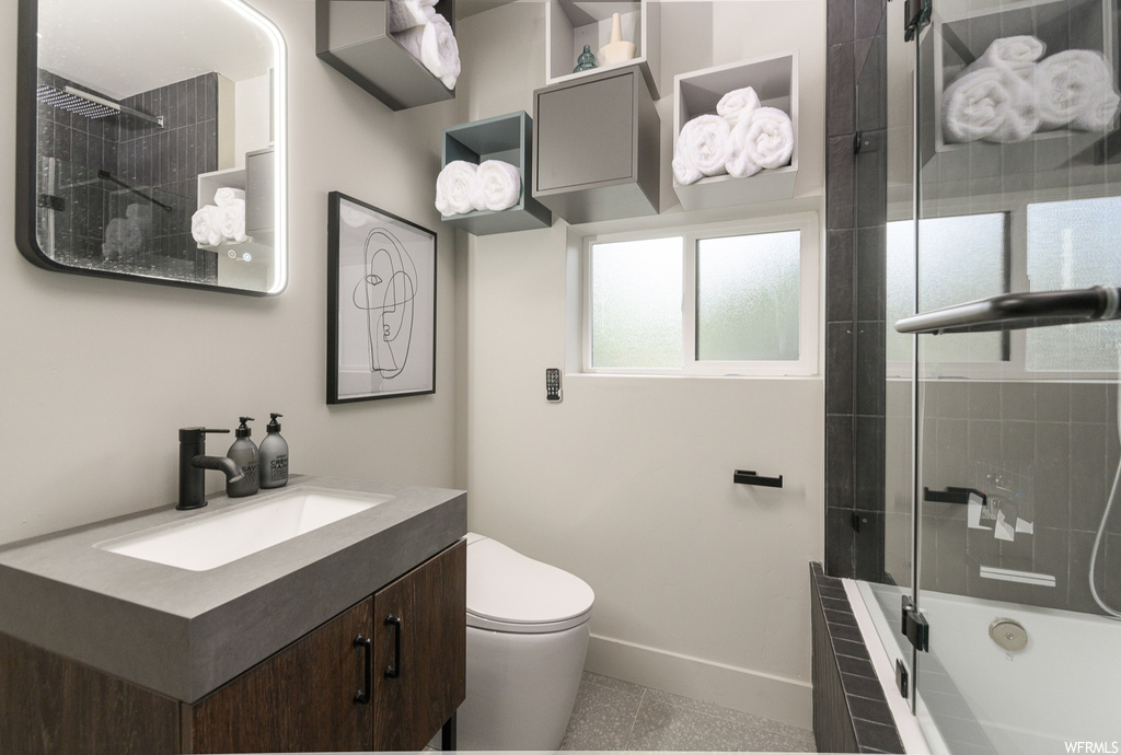Full bathroom with tiled shower / bath combo, light tile floors, oversized vanity, and mirror