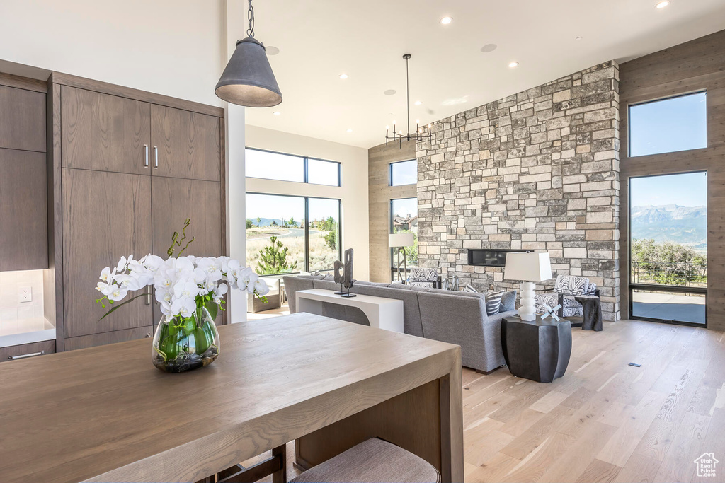 Interior space featuring plenty of natural light, a towering ceiling, and light wood-type flooring