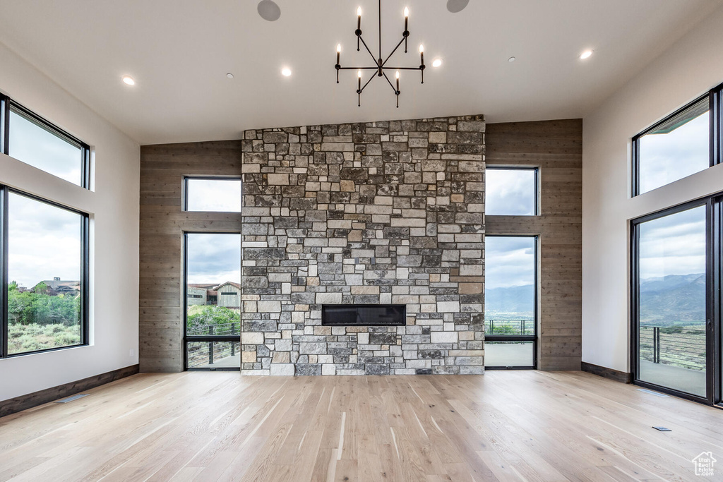 Unfurnished living room featuring a fireplace, light wood-type flooring, and a healthy amount of sunlight