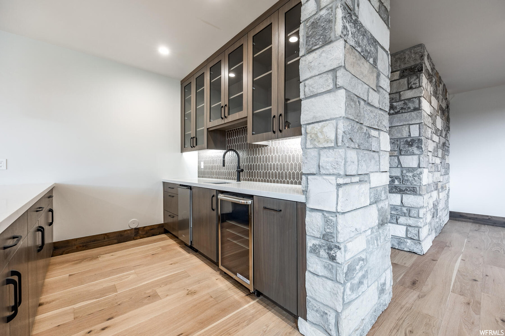 Kitchen featuring light hardwood flooring, light countertops, and backsplash