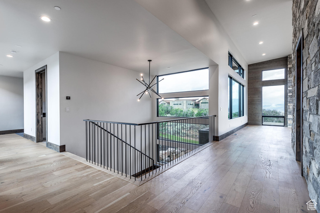 Corridor featuring light hardwood / wood-style floors and a notable chandelier