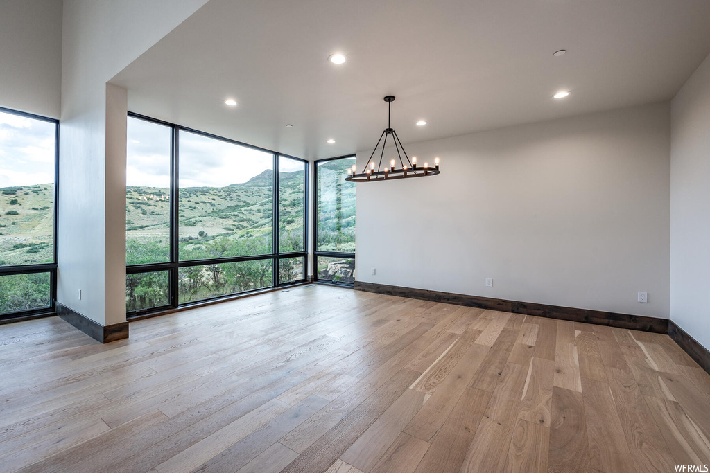 Spare room featuring plenty of natural light, expansive windows, and light hardwood floors