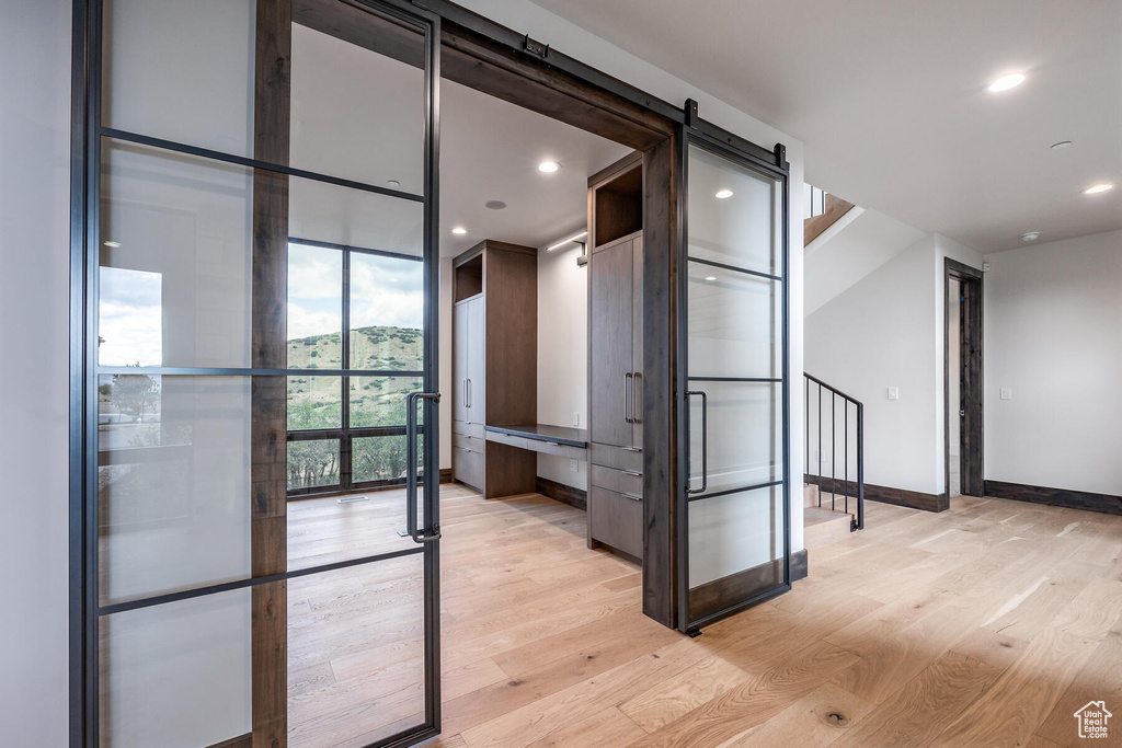 Hall featuring a barn door and light hardwood / wood-style floors