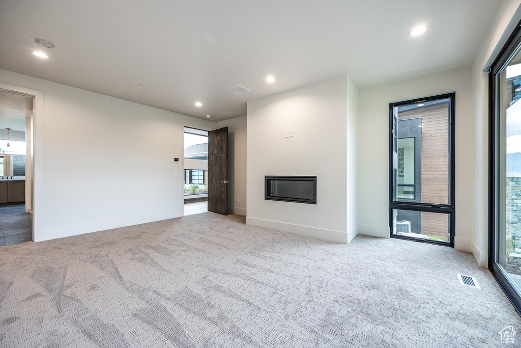 Unfurnished living room with plenty of natural light and light carpet