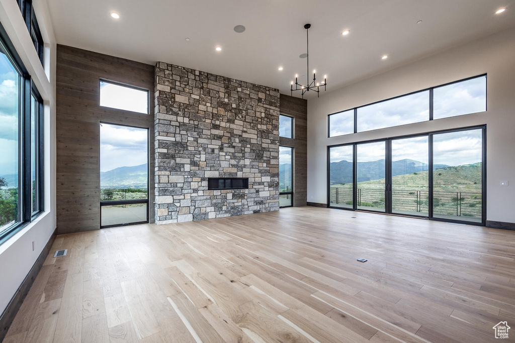 Unfurnished living room featuring light hardwood / wood-style flooring, a mountain view, and a healthy amount of sunlight