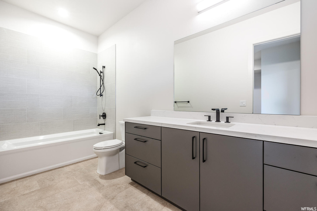 Full bathroom featuring tiled shower / bath combo, oversized vanity, light tile flooring, and mirror