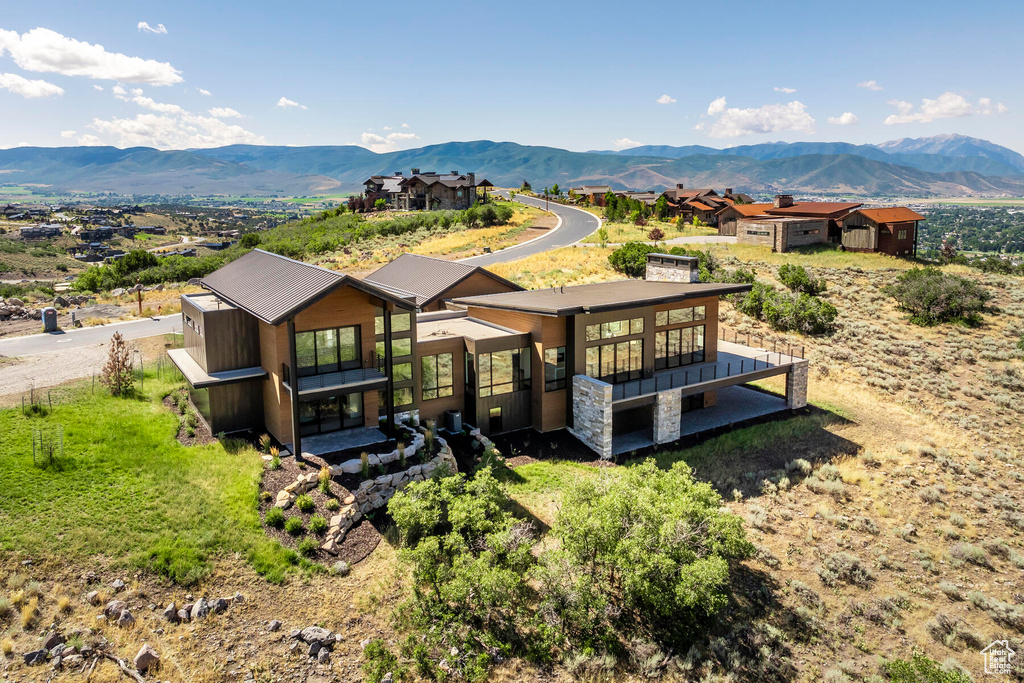 Rear view of property with a mountain view and a balcony