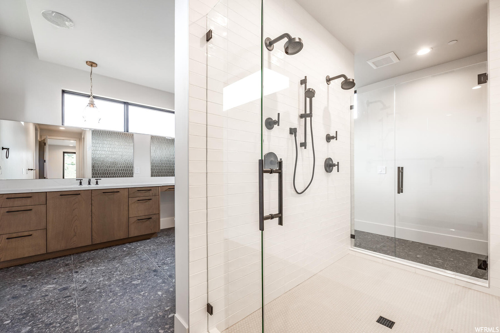 Bathroom with tile floors, vanity, mirror, and a shower with shower door