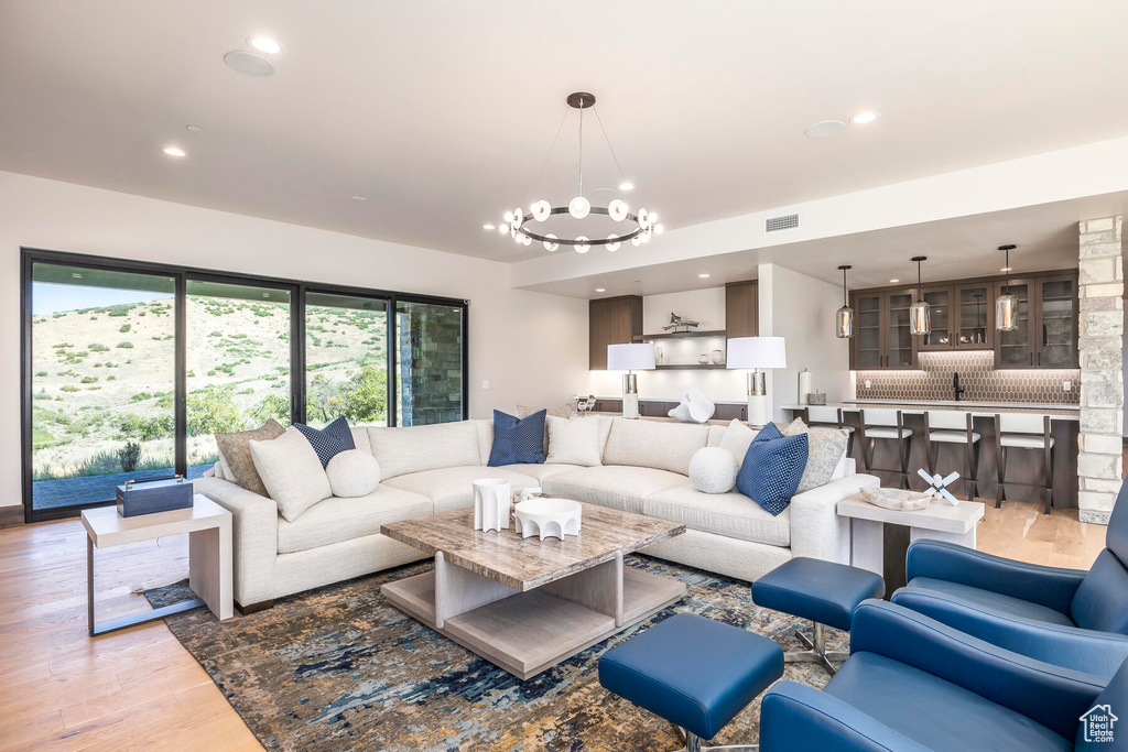 Living room featuring sink, an inviting chandelier, and light hardwood / wood-style flooring