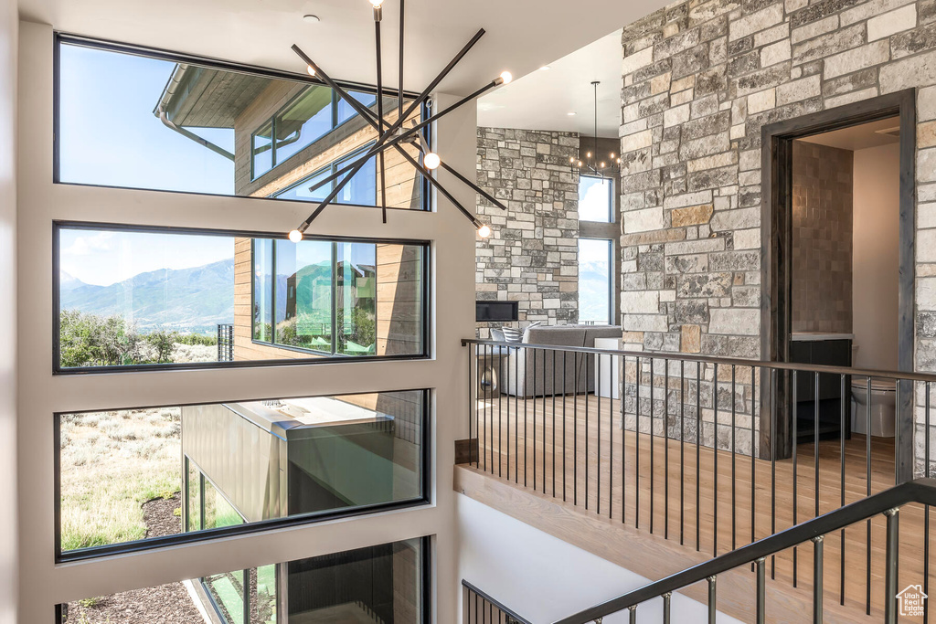 Interior space with a mountain view, a notable chandelier, wood-type flooring, and a high ceiling