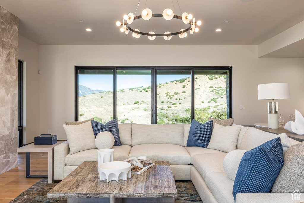 Living room with a mountain view, an inviting chandelier, and wood-type flooring