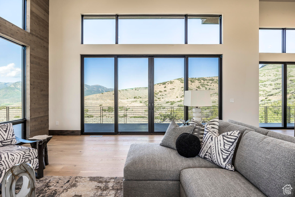 Living room featuring a mountain view, a towering ceiling, and light wood-type flooring