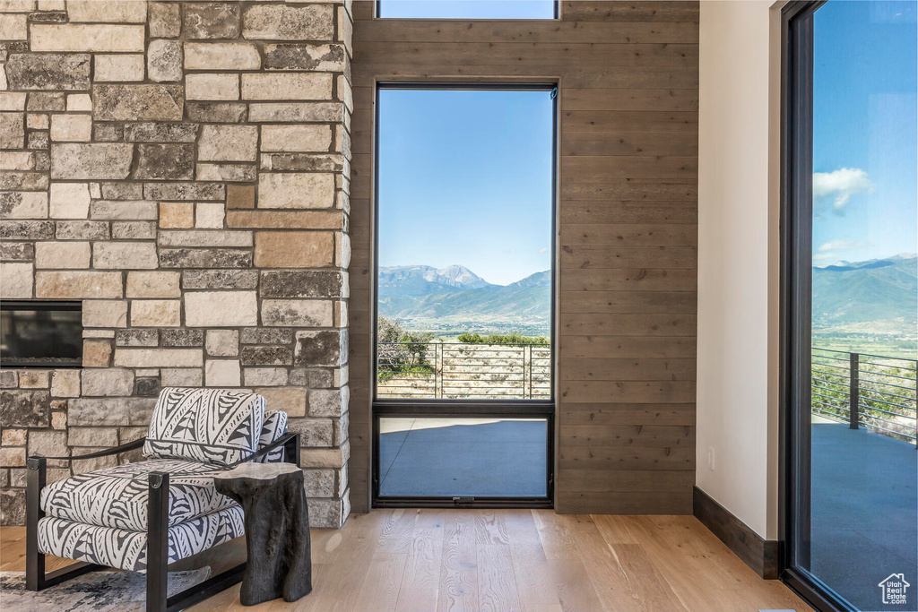 Doorway to outside with a mountain view, wooden walls, and light hardwood / wood-style floors