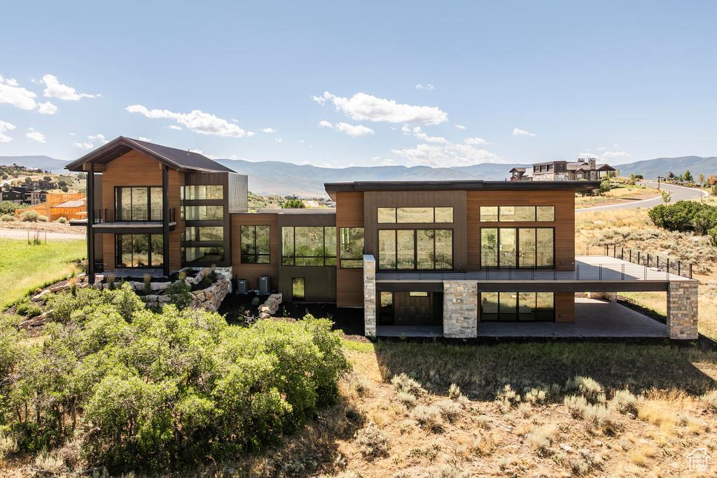 Rear view of house featuring a mountain view and a patio