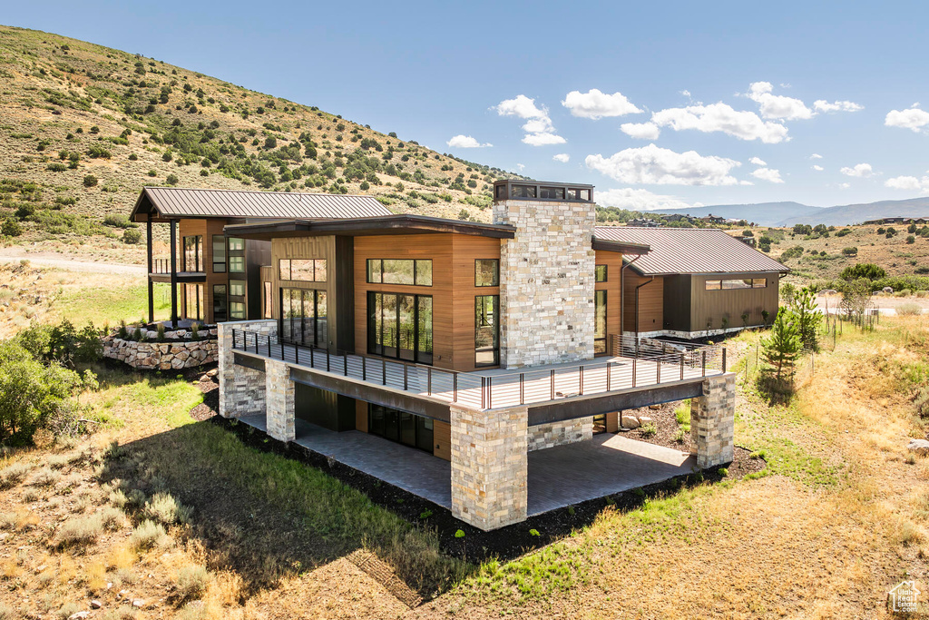 Back of house featuring a patio area and a deck with mountain view