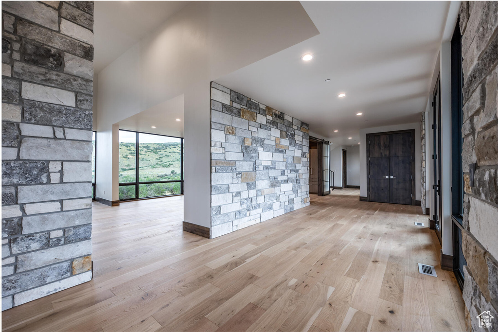 Spare room with light wood-type flooring, a wall of windows, and a barn door