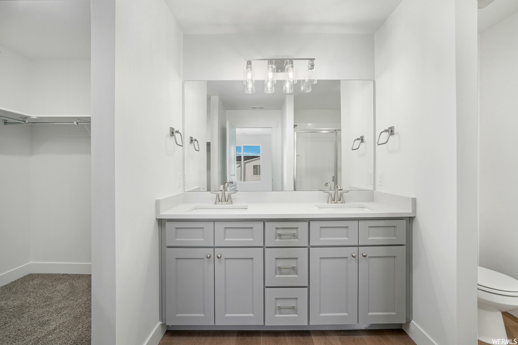 Bathroom featuring mirror, wood-type flooring, and dual large bowl vanity