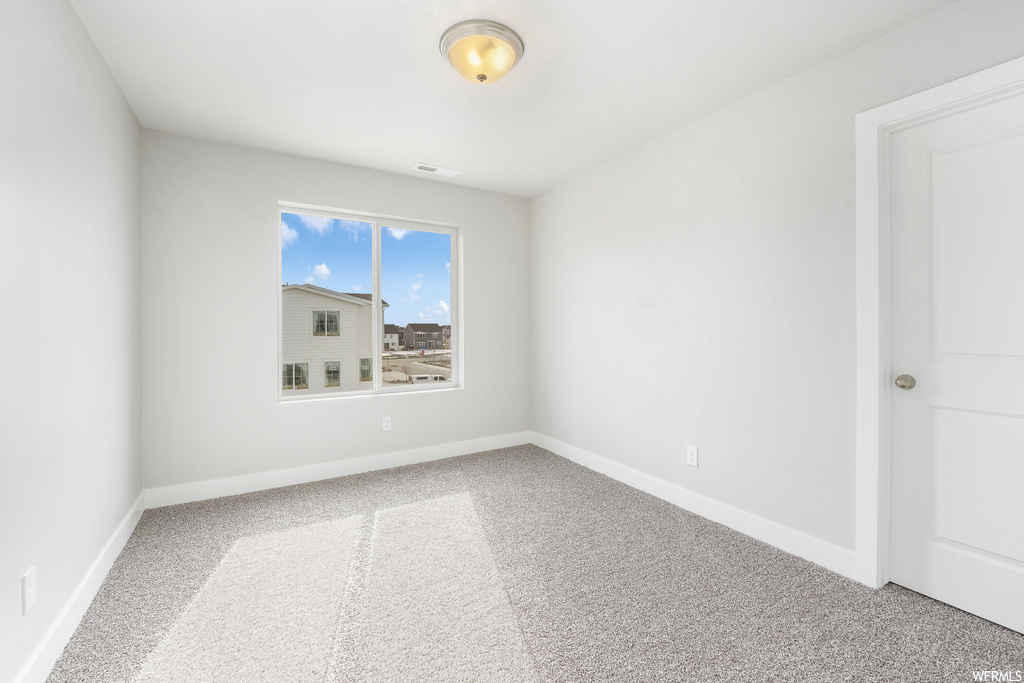 Spare room featuring light carpet