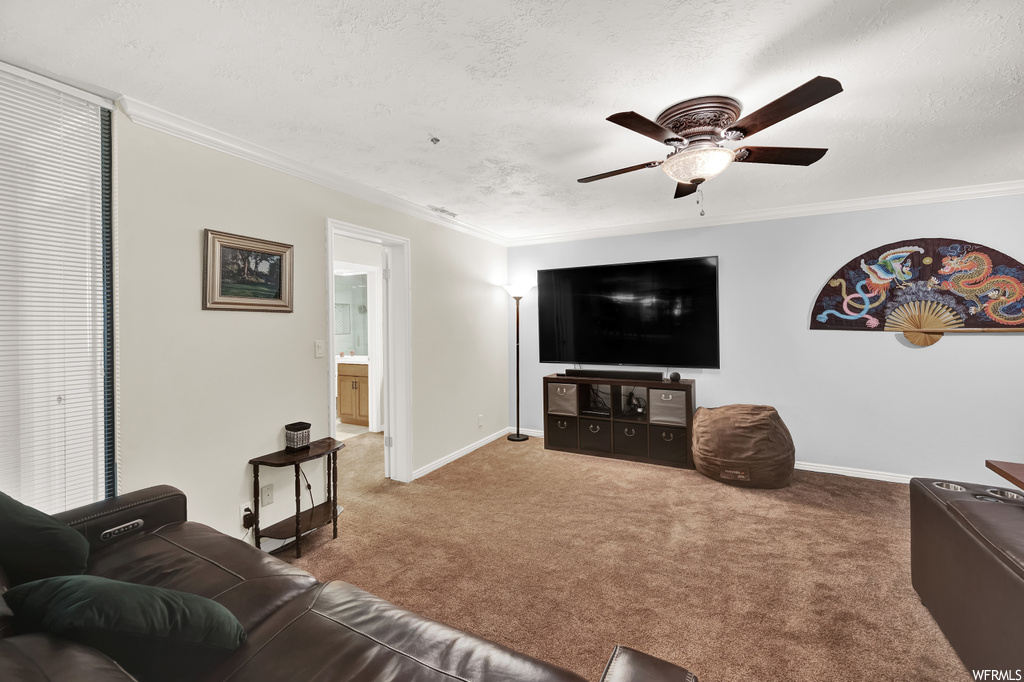 Living room with crown molding, carpet, and ceiling fan