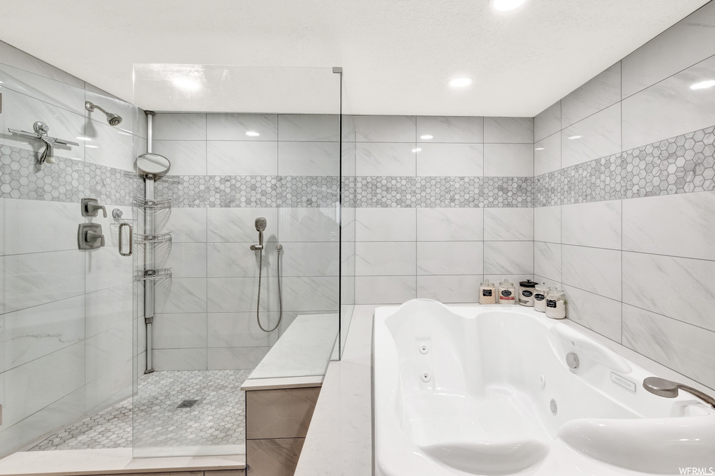 Bathroom with tile walls and plus walk in shower