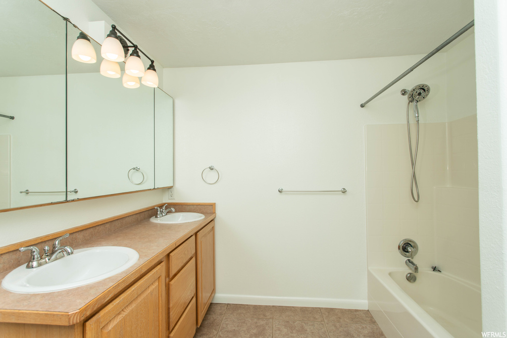 Bathroom with dual vanity,  shower combination, mirror, and light tile floors