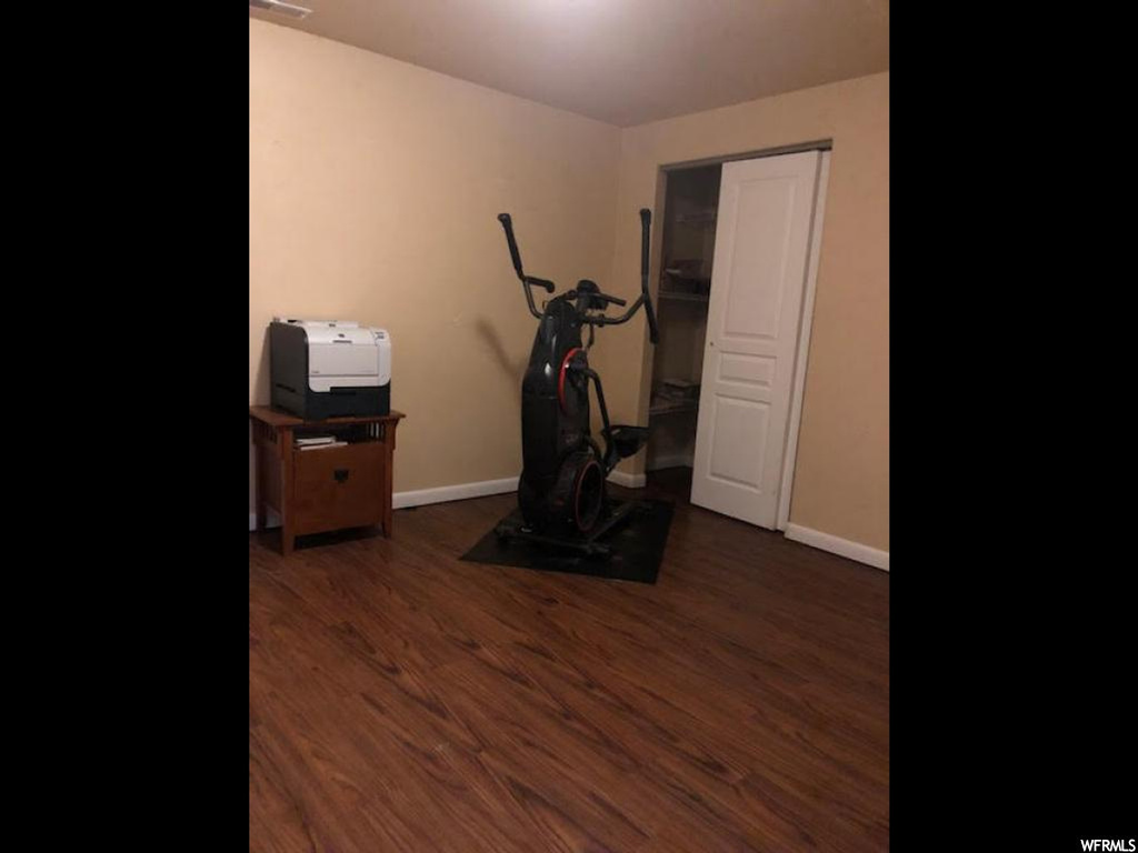 Exercise room featuring dark hardwood floors