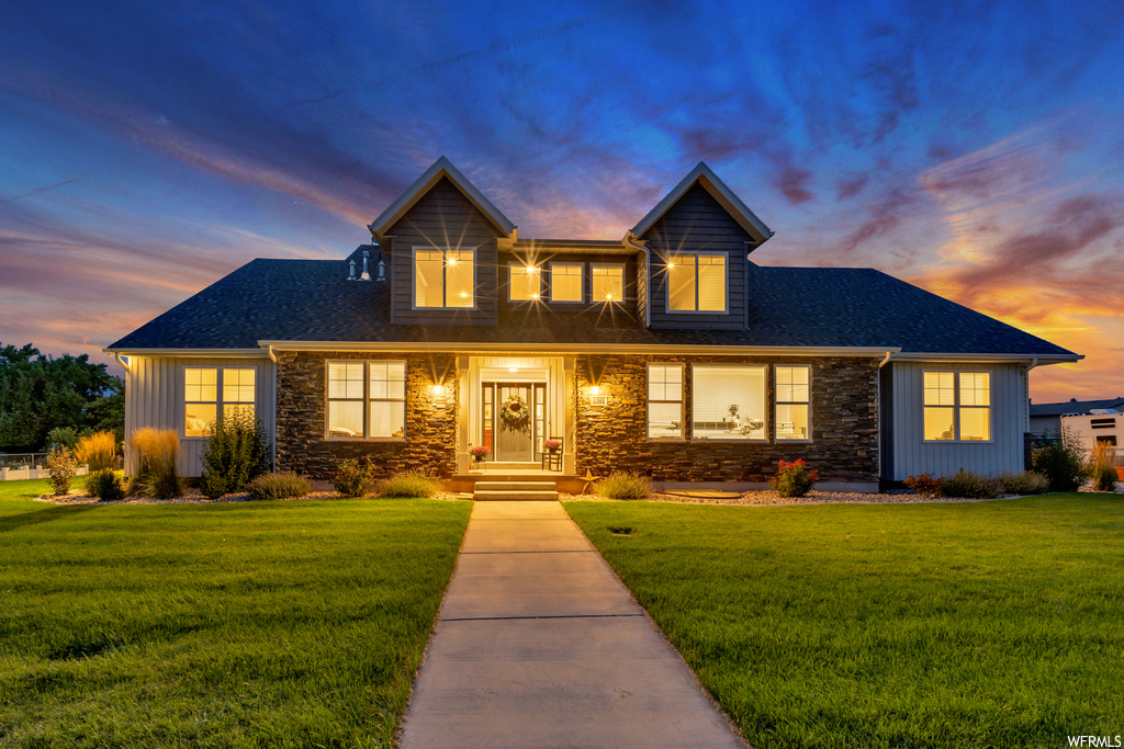 View of front of home with a porch and a yard