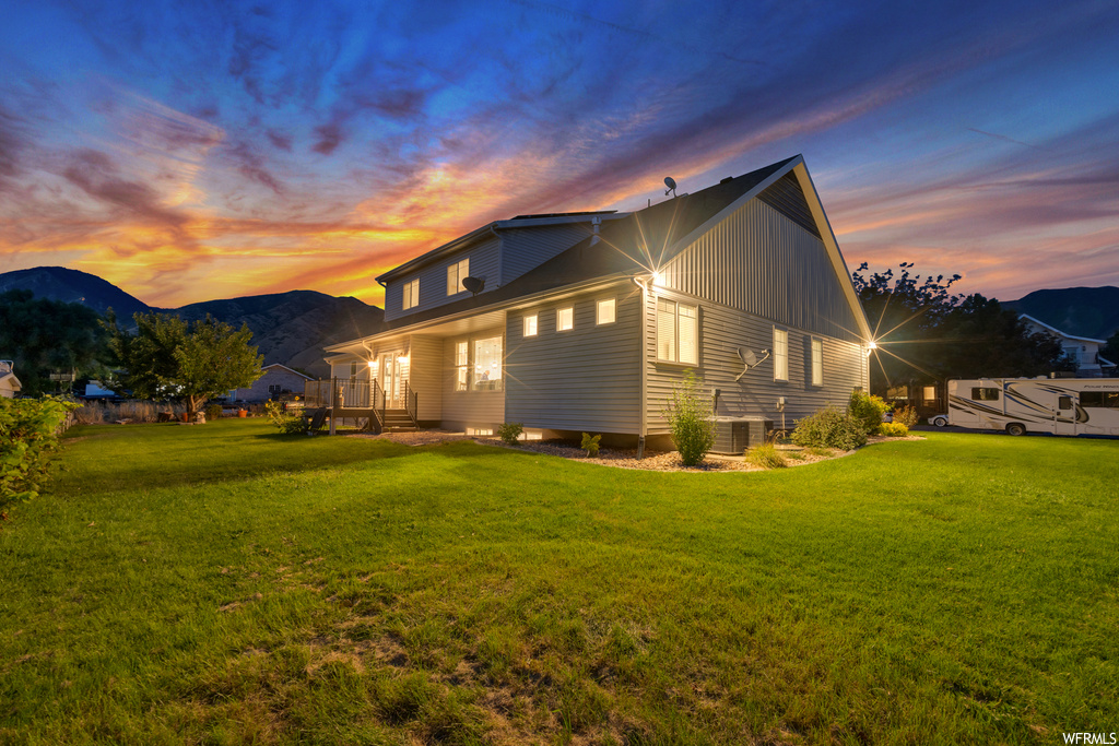 Exterior space with a mountain view and a lawn