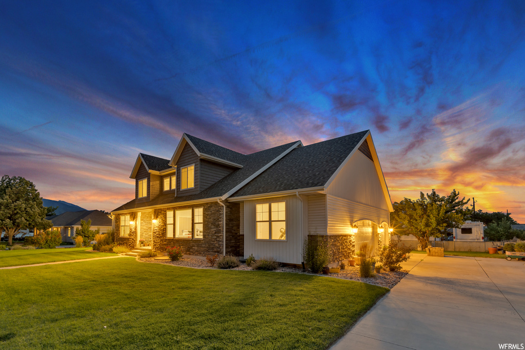 View of front facade featuring garage and a lawn