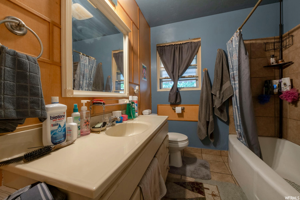 Full bathroom featuring tile flooring, mirror, shower / bathtub combination with curtain, and vanity