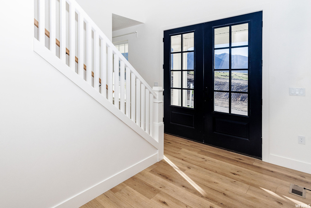 Entryway with french doors and light hardwood flooring