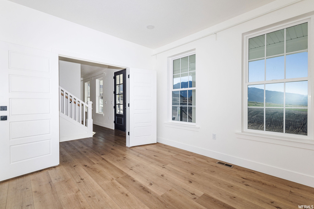 Spare room featuring light hardwood flooring and a mountain view