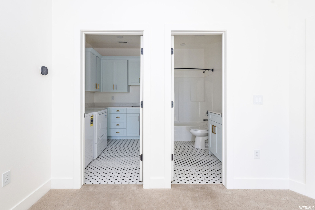 Bathroom with toilet, vanity, a bidet, and tile flooring