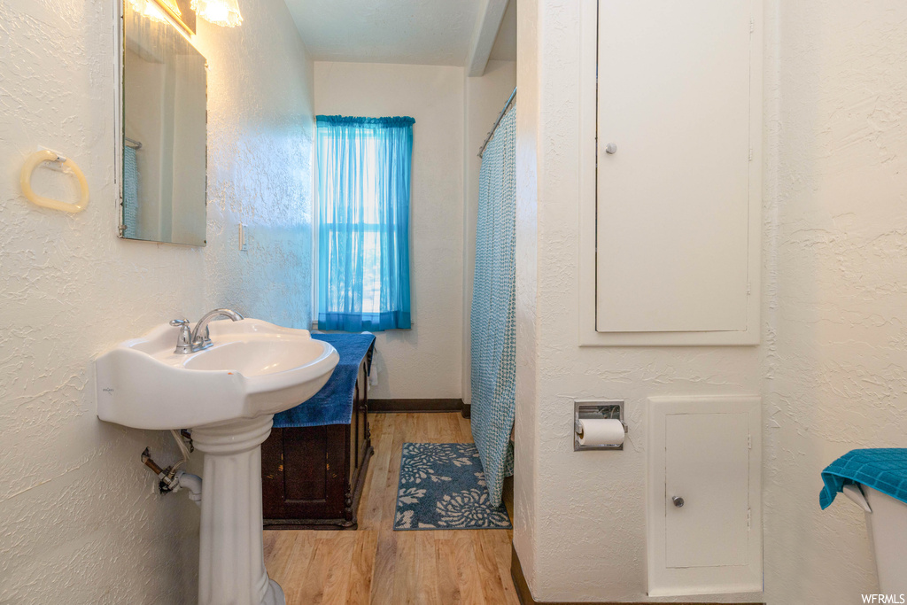 Bathroom featuring sink, hardwood floors, and mirror
